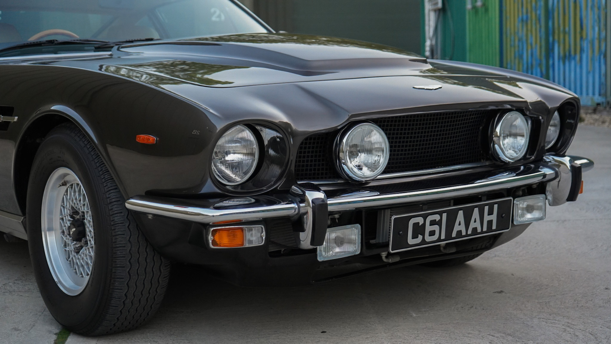 Dark brown 1985 Aston Martin V8 Saloon Series 4 “Oscar India” showing the front bumper and headlights detail.