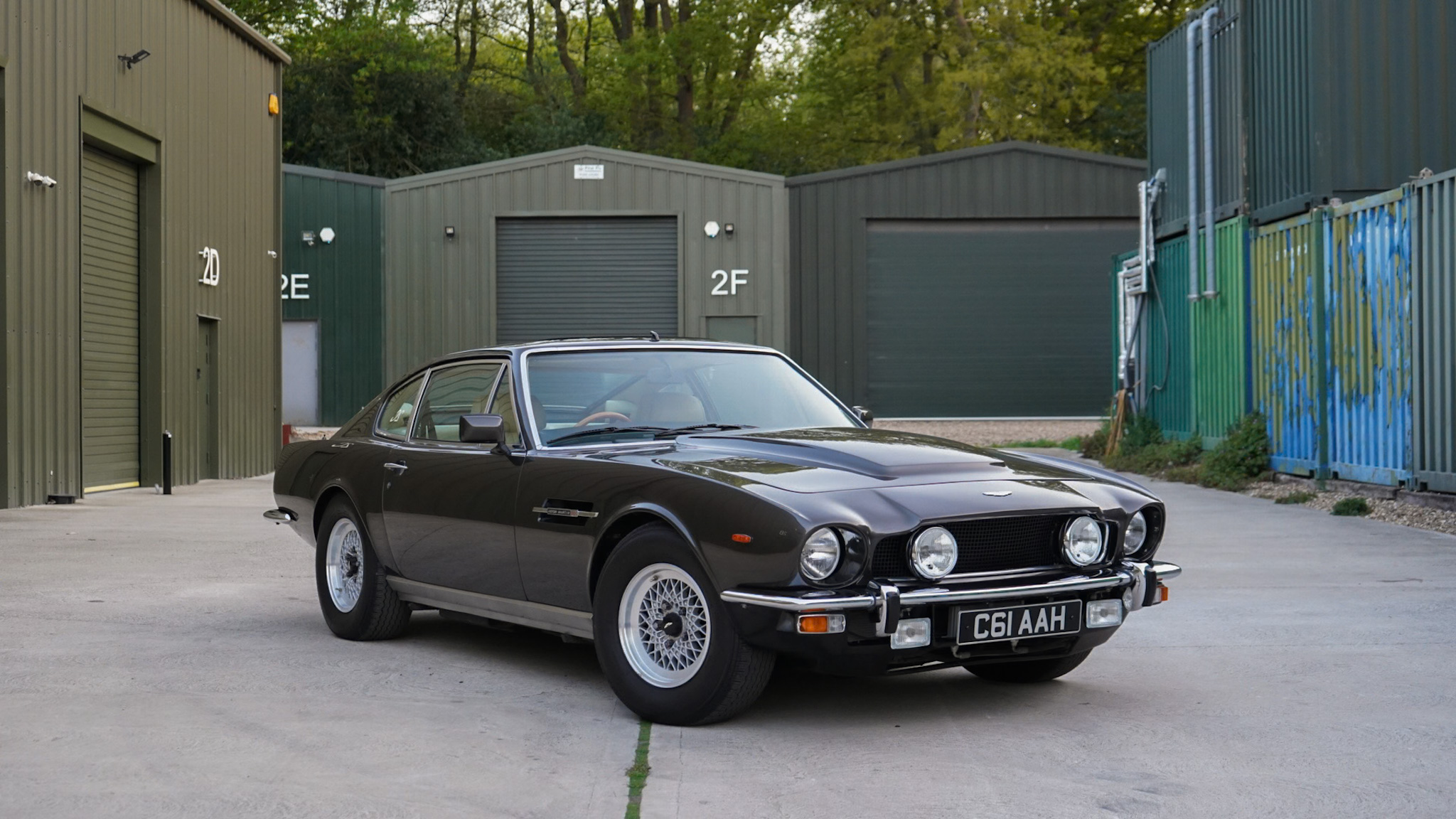 Dark brown 1985 Aston Martin V8 Saloon Series 4 “Oscar India” in a wide front three-quarter view.