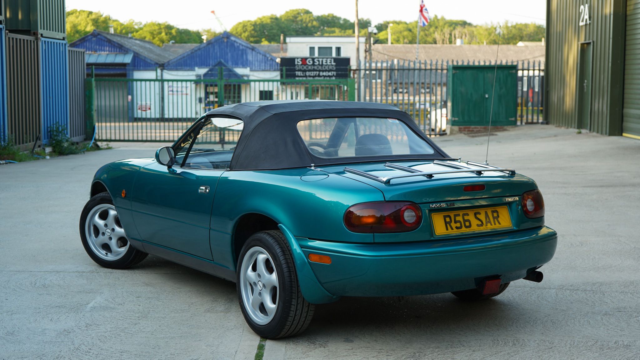 Green 1998 Mazda MX-5 Berkeley Edition in a wide rear three-quarter view.