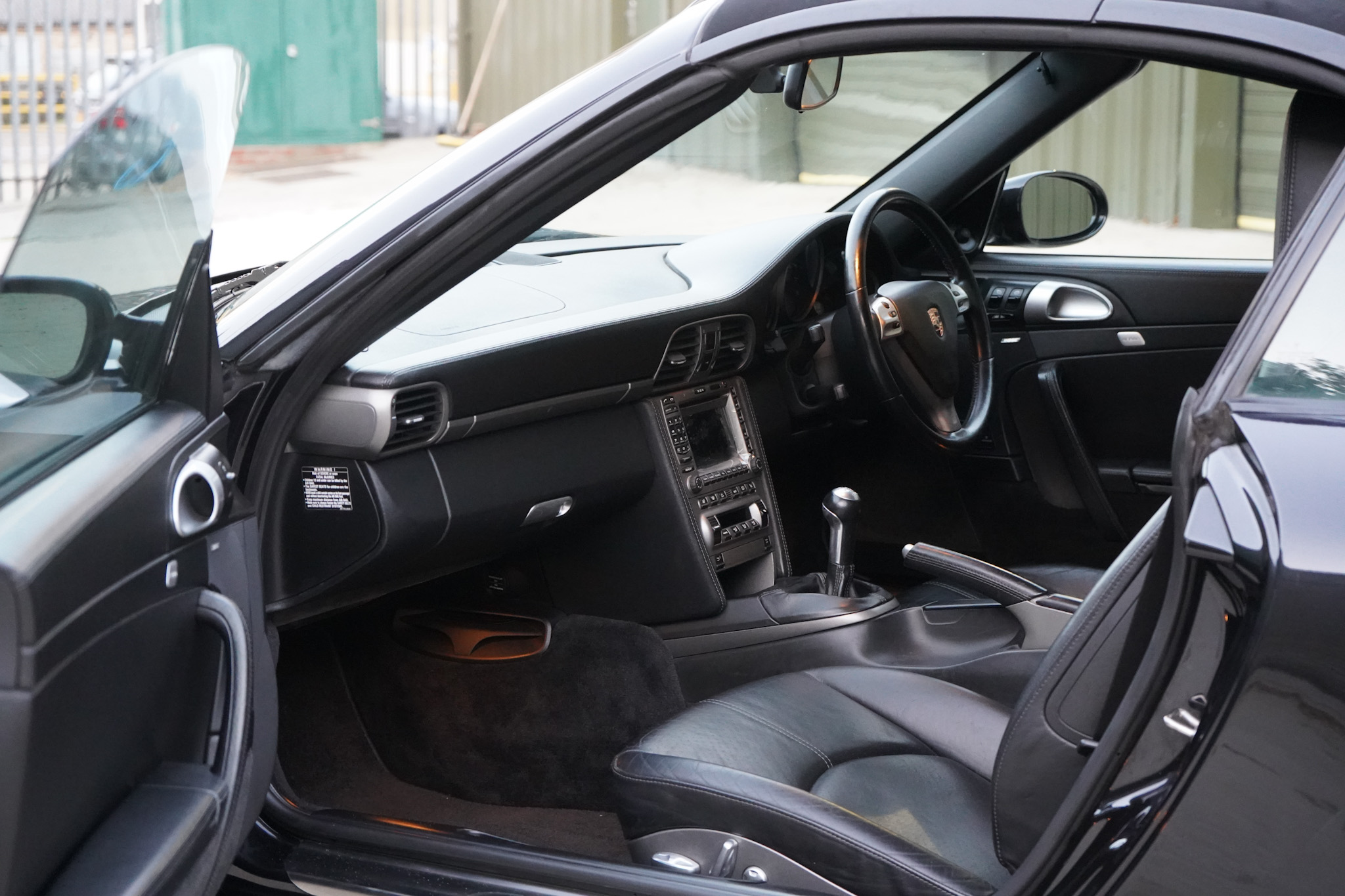 2006 Porsche 911 (997) Carrera Cabriolet interior showing the passenger side cabin door open.