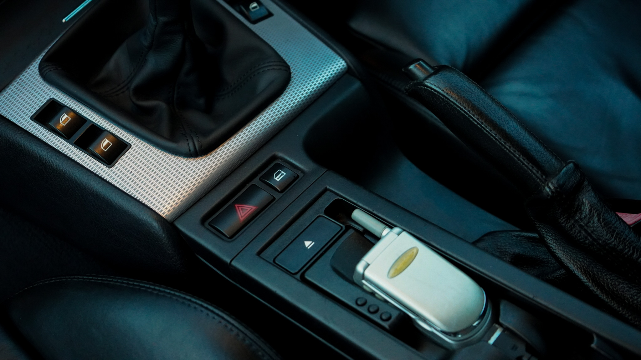 2002 BMW M3 (E46) Manual interior showing the centre console switches and handbrake.