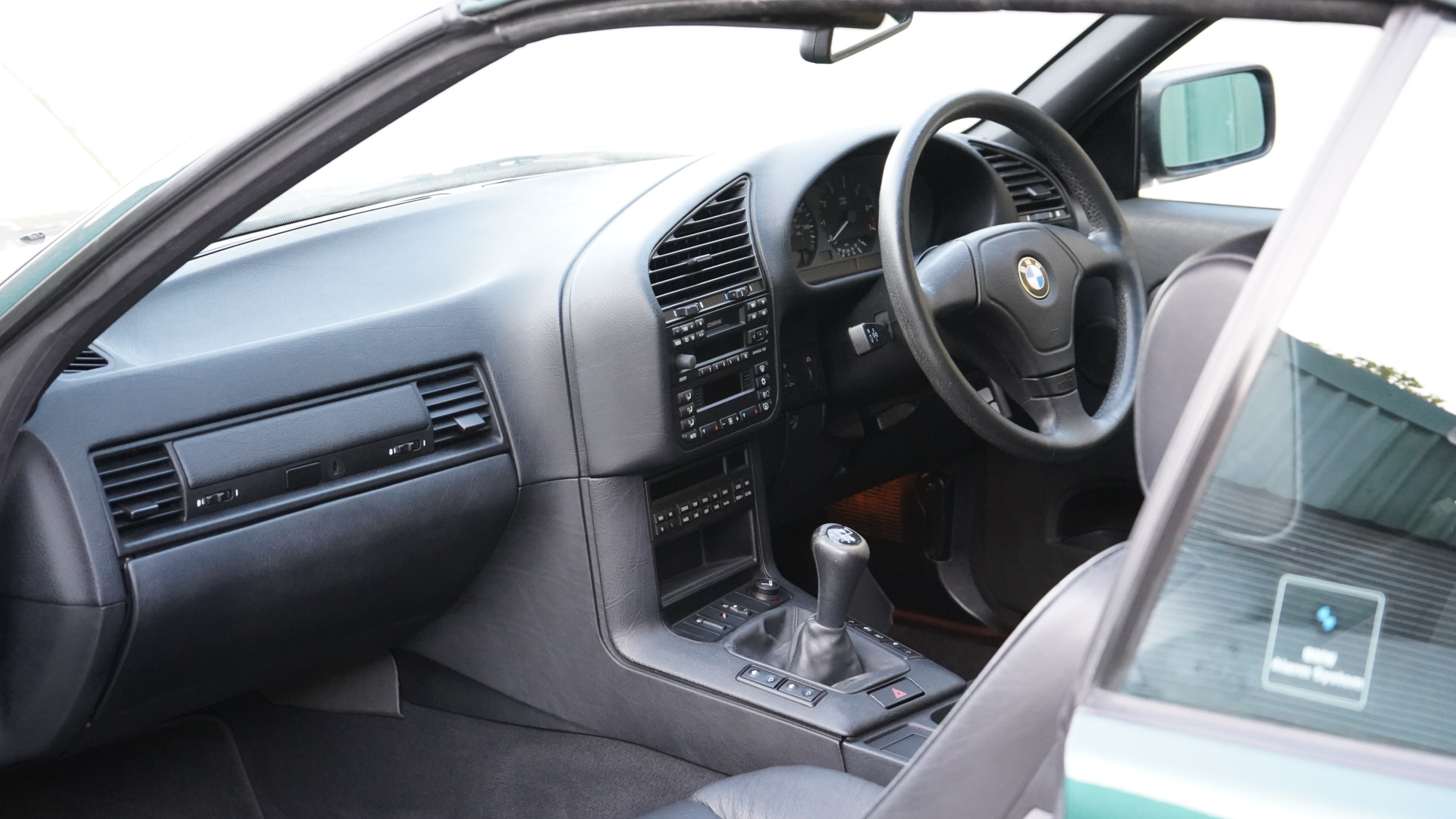 BMW 328i (E36) Manual Convertible interior showing the dashboard and manual gear shifter.