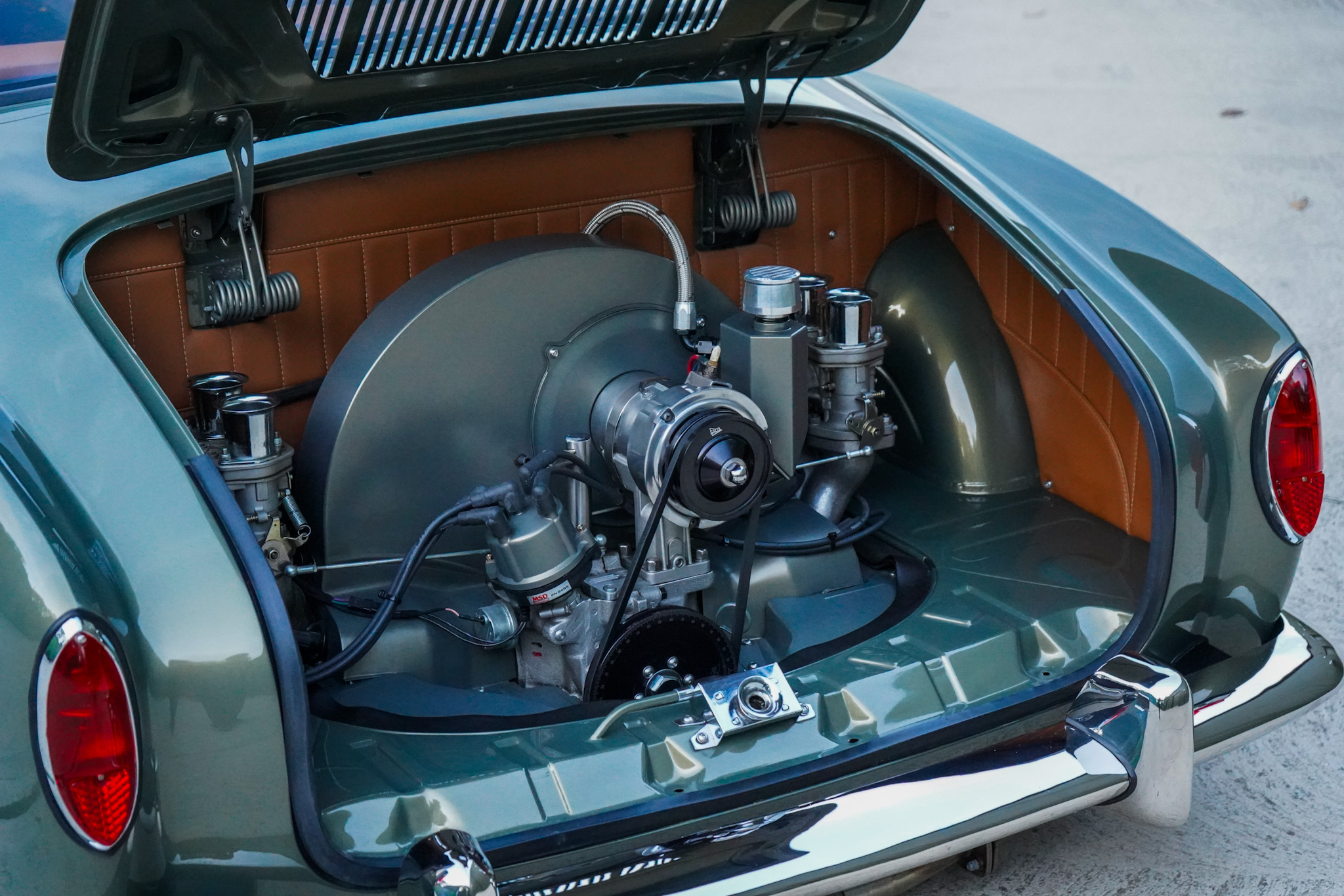 Green Volkswagen Karmann Ghia Type 14 Restomod showing the open engine bay from a rear three-quarter angle.