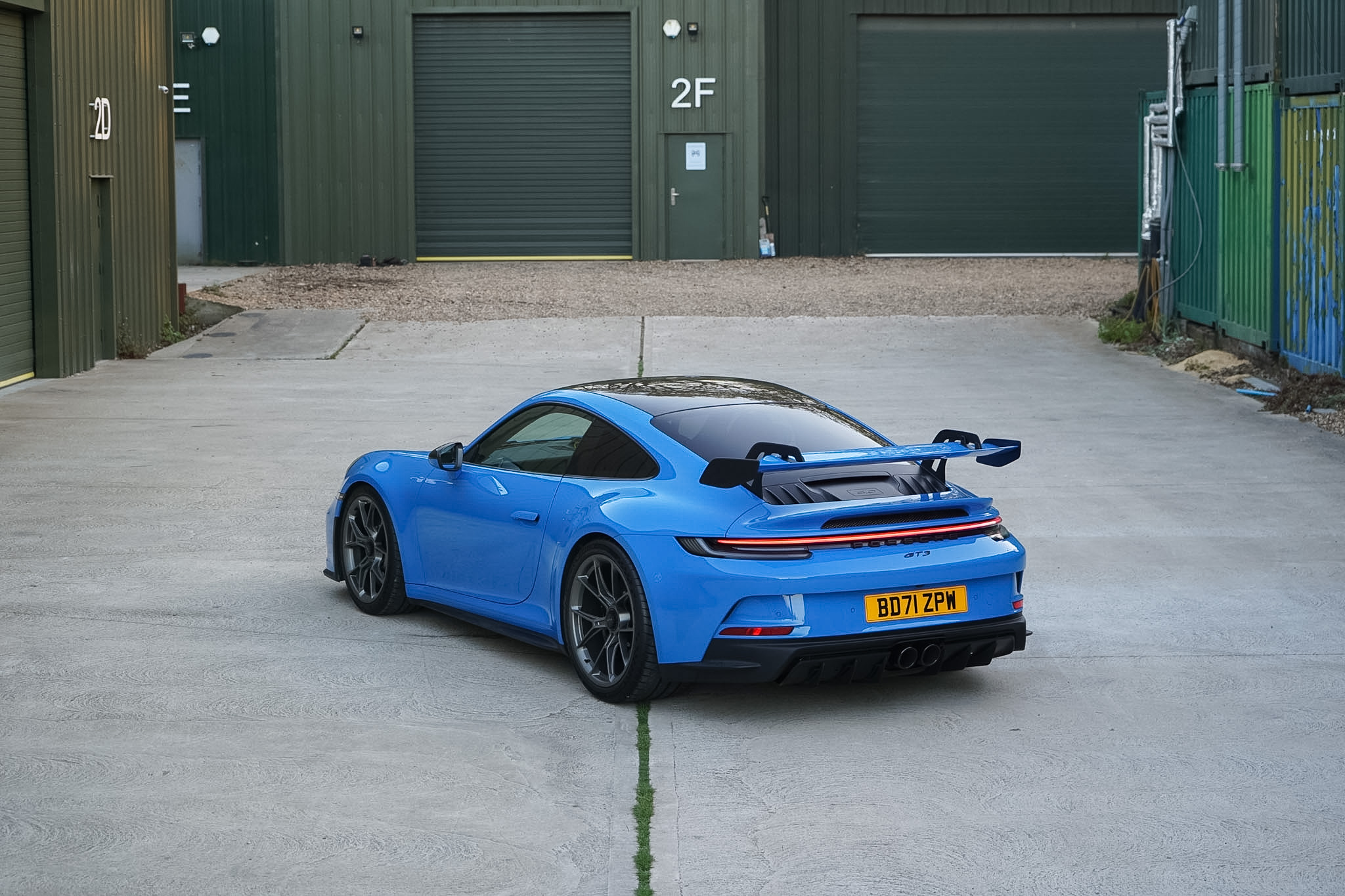 Blue 2022 Porsche 911 (992) GT3 high-angle rear three-quarter view.