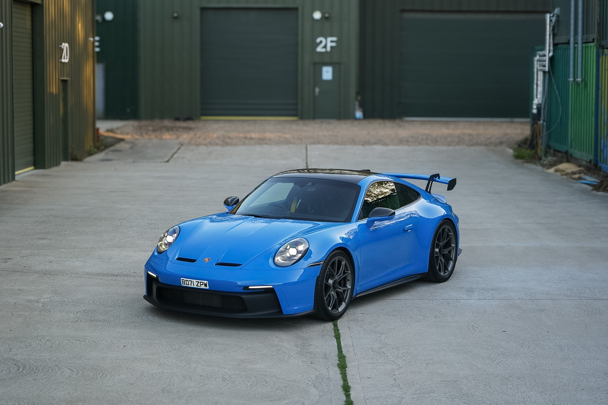 Blue 2022 Porsche 911 (992) GT3 wide front three-quarter view.