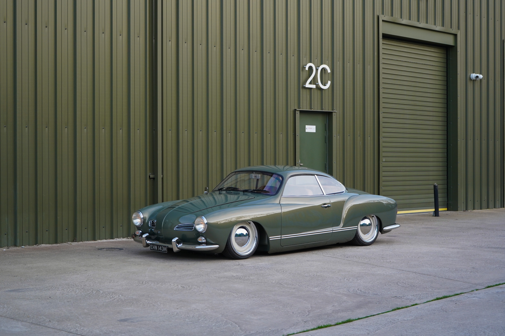Green Volkswagen Karmann Ghia Restomod alternate wide front three-quarter view.