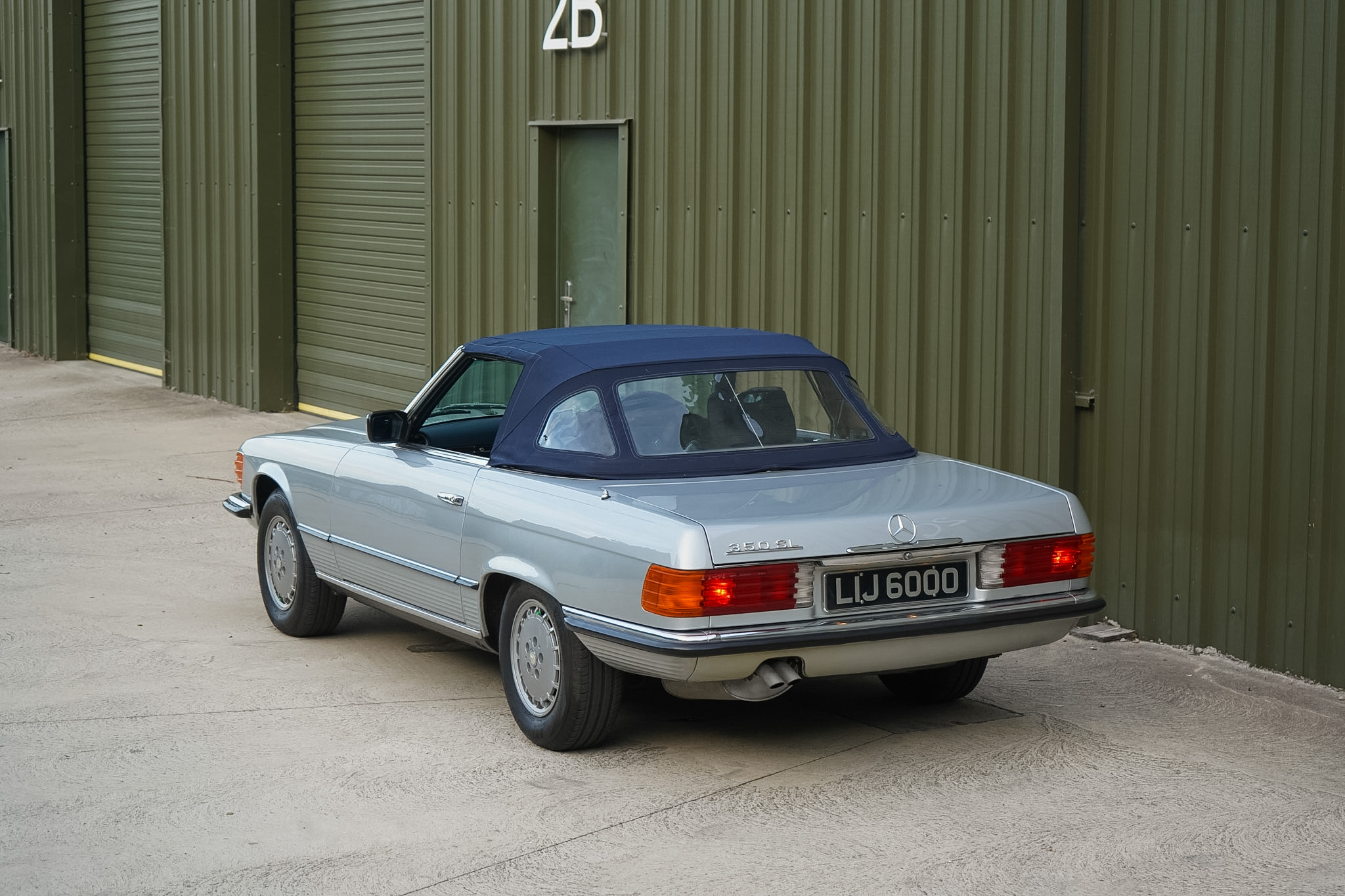 Silver Mercedes-Benz 350 SL (R107) rear three-quarter view with soft top raised.
