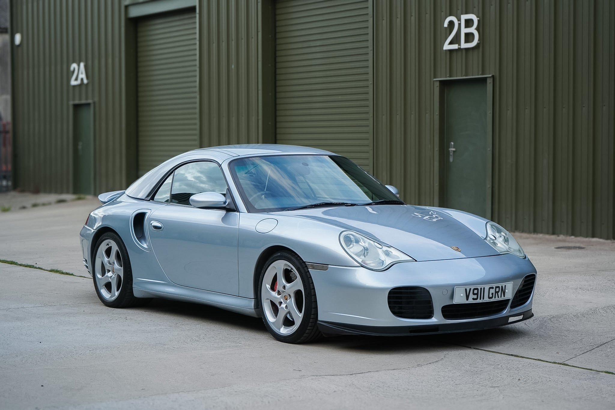 Silver Porsche 911 (996) Turbo X50 Cabriolet front three-quarter view with soft top raised.