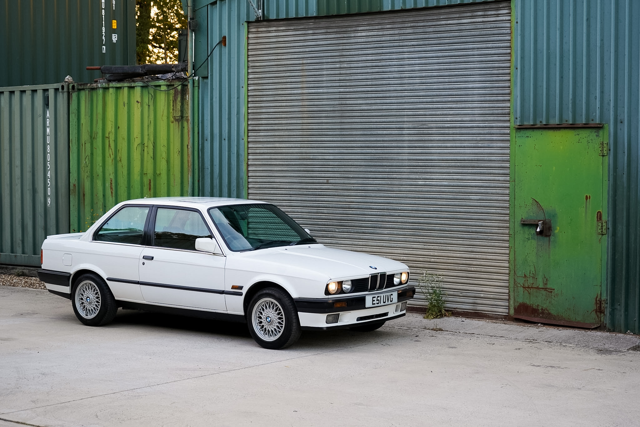 White BMW 325i (E30) Manual Coupe front three-quarter view from the opposite side.