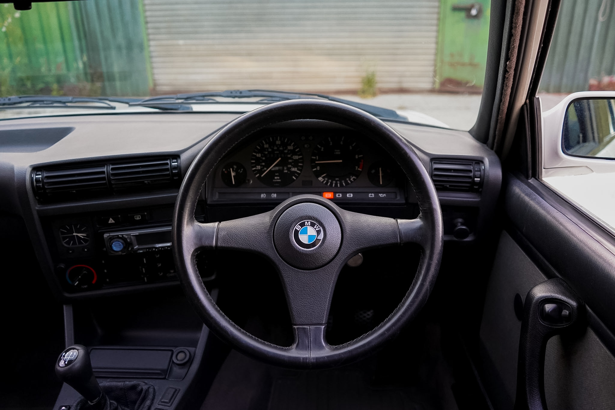 BMW 325i (E30) Manual Coupe steering wheel and dashboard view.