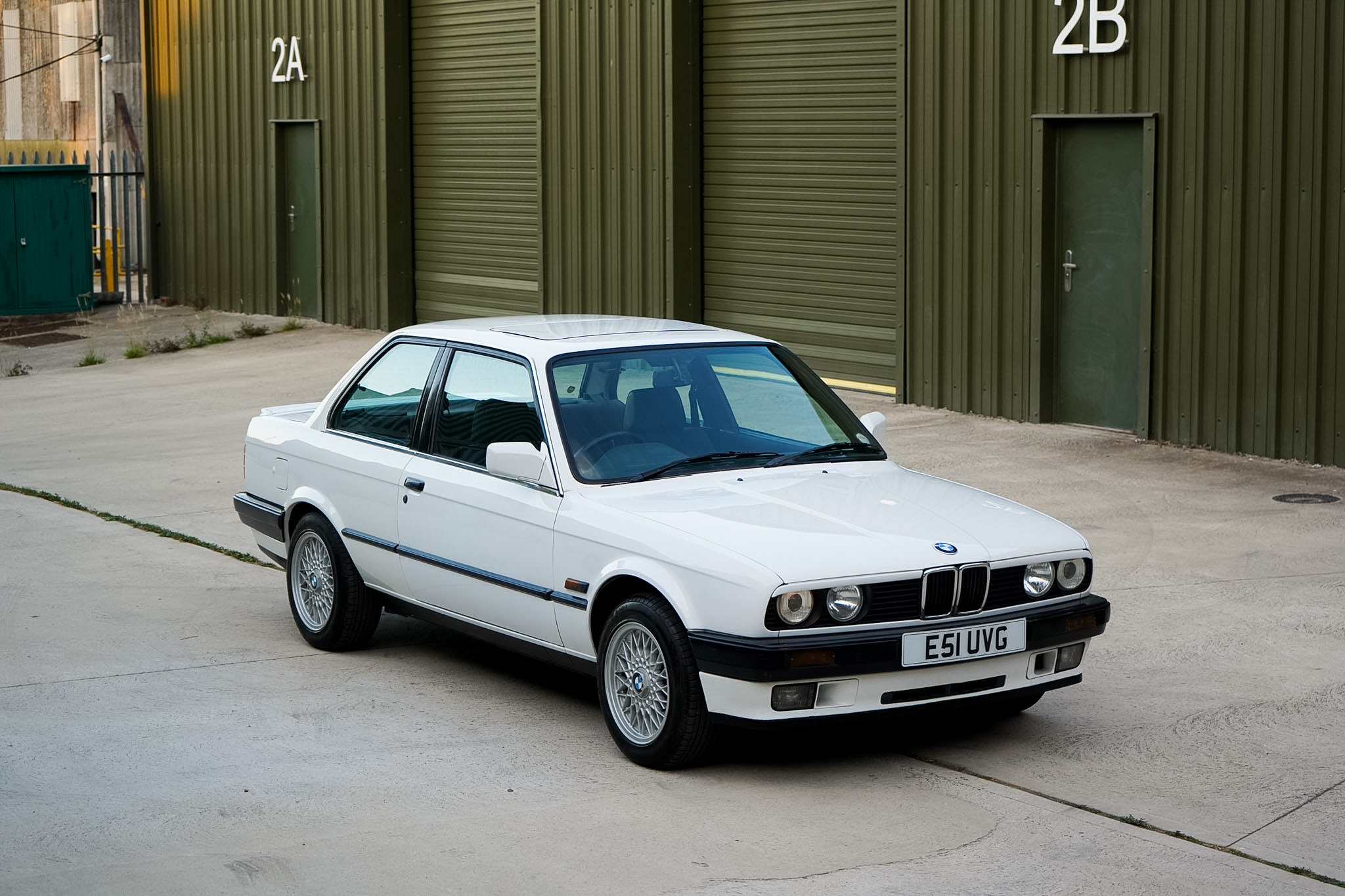 White BMW 325i (E30) Manual Coupe wide front three-quarter view.